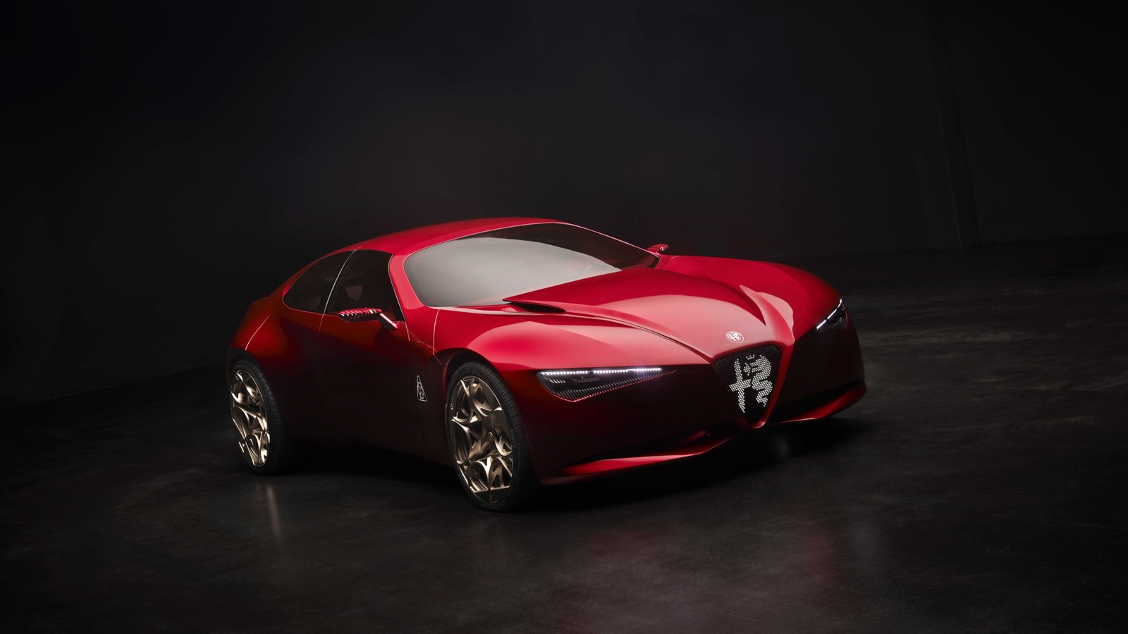 Alfa Romeo Cuorerosso concept in Liquid Ink red, a low four-seat fastback with a shield-shaped grille, slim headlights and bronze wheels in a dark studio