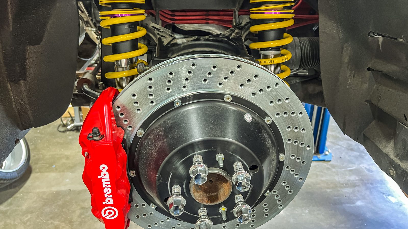 Red Brembo caliper, drilled rotor and yellow coilover on the Tesoro
