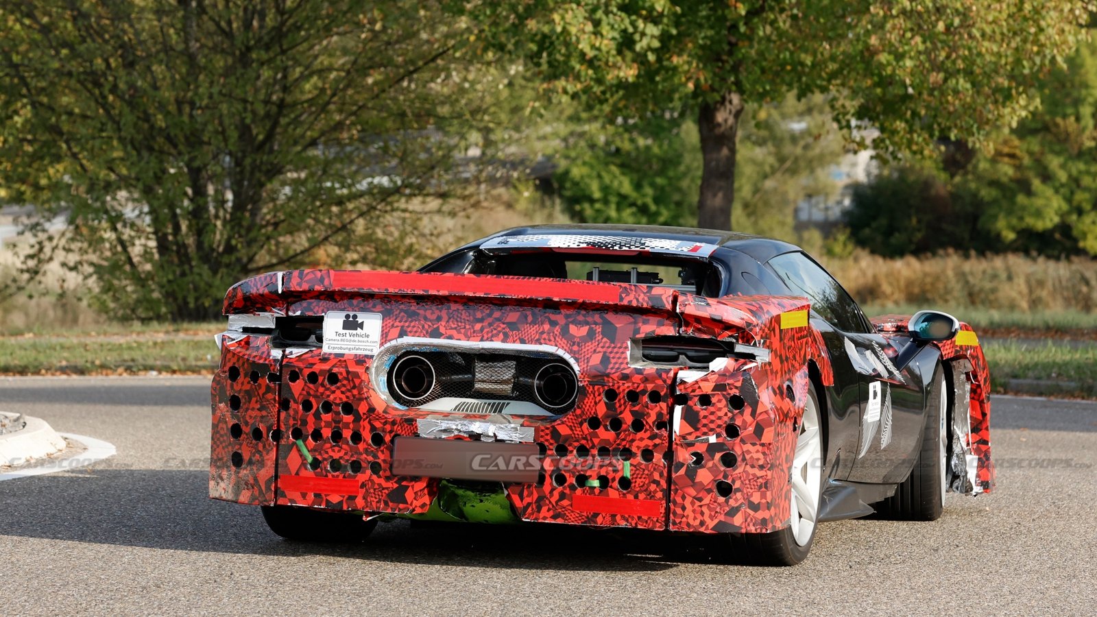 Rear view of the camouflaged 296 Challenge Stradale prototype with twin high-mounted round exhaust tips and reshaped diffuser