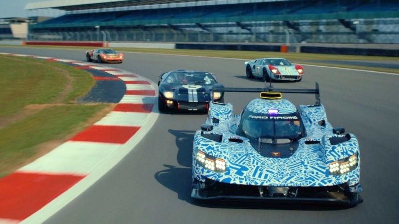 Camouflaged Ford Le Mans Hypercar prototype leading a GT40 and two Ford GTs around Silverstone in Ford Racing's reveal teaser