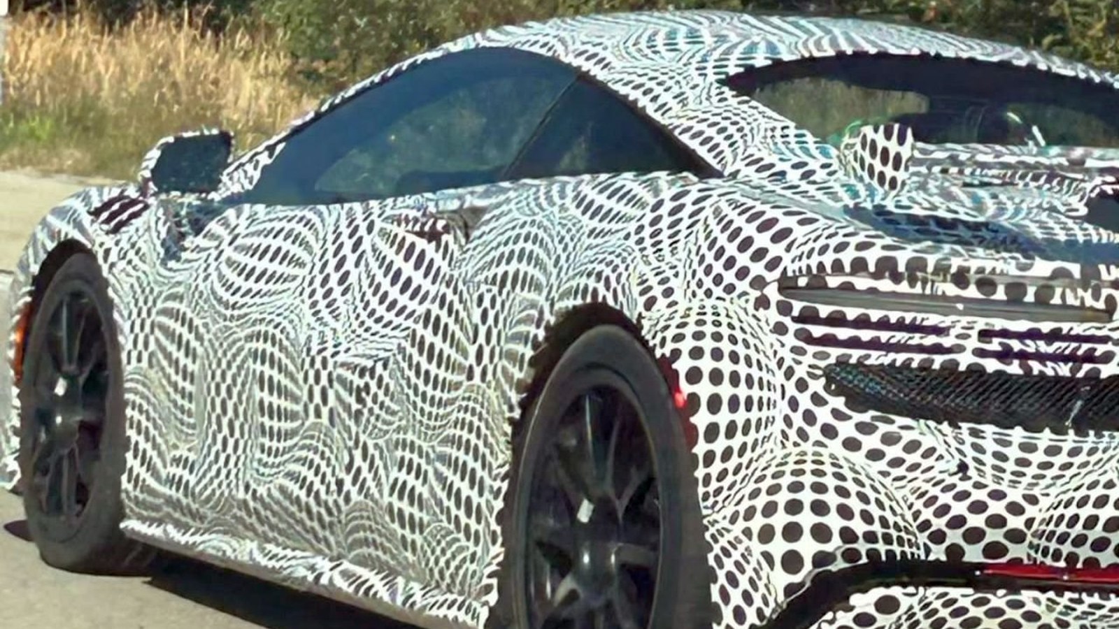Side and rear three-quarter of the camouflaged McLaren prototype showing Artura-like proportions and a revised rear deck