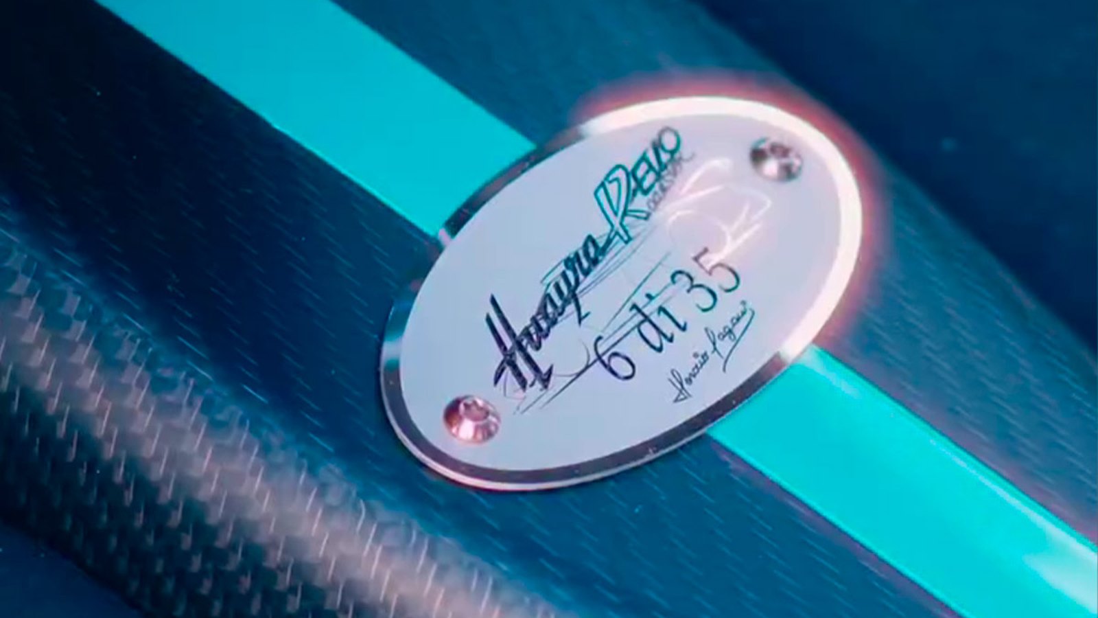 Oval Huayra R Evo plaque reading 6 di 35 with Horacio Pagani's signature, set into exposed carbon with a teal stripe