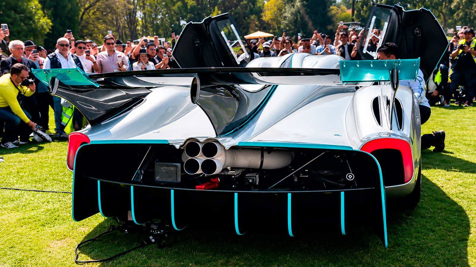Rear of the Pagani Huayra R Evo Roadster on the lawn, showing its central quad exhaust, teal-trimmed diffuser fins and large rear wing
